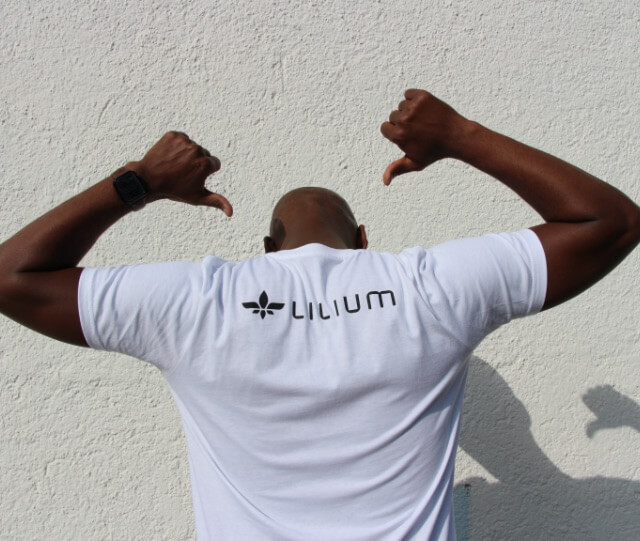 A Lilium employee pointing to the Lilium logo on his t-shirt